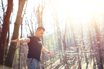 Man standing in nature with arms outstretched