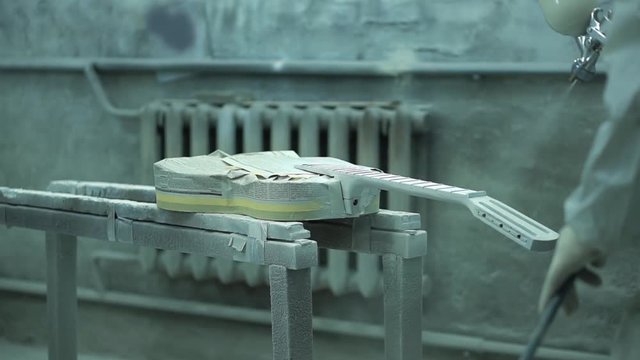 Painter using a paint sprayer for a guitar and creates props for the filming