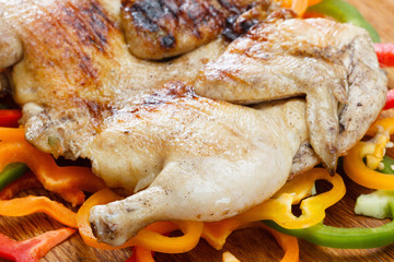 Fried crusted grilled chicken on a colorful background of vegetables