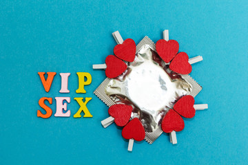 Condom and red hearts on a blue background, the inscription "vip sex"