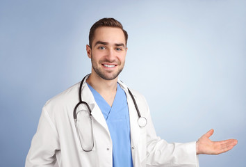 Handsome young doctor on light background