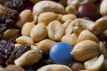 Close up of pile of trail mix with nuts, raisins, and candy