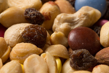 Close up of pile of trail mix with nuts, raisins, and candy