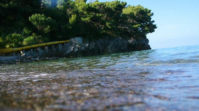 Underwater photography, you can see the beach. The sea coast of Montenegro, the city of Petrovac, the Adriatic.