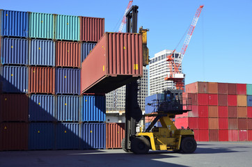 Toplifter handling cargo container loading to container trailer in import export logistic zone
