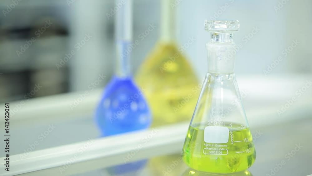 Aufkleber laboratory glassware with color liquid and with reflection. test tubes and flasks with green and blu