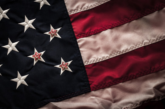 Soviet star on top of the american flag (Star and Stripes) symbolizing Russia's involvement in influencing the election in the United States of America. Desaturated dark grungy image