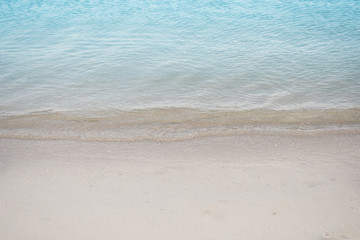 Fototapeta na wymiar Clear blue water and gentle in the tropical beach for summer relaxation.