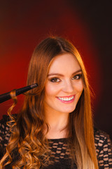 Obraz premium Happy woman curling her long brown hair