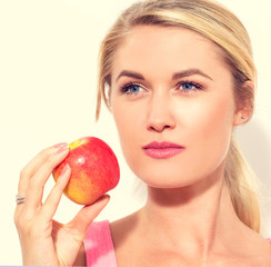 Happy young woman holding apple