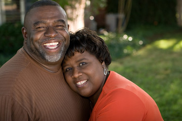 Mature African American couple laughing and hugging. - Powered by Adobe