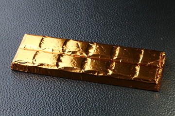 Chocolate bar in aluminum foil packaging represent the food and confectionery concept related idea.