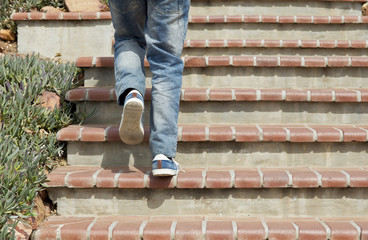 Adult male walking up cement tiled stairs