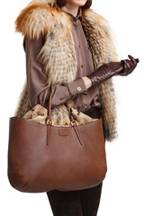 Girl holds a brown bag close-up on an isolated white background