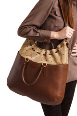 Girl holds a brown bag close-up on an isolated white background