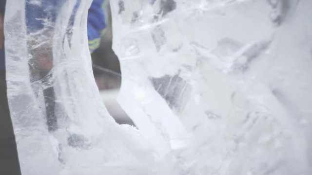 Master Scraper Performs A Movement Across The Ice To Create An Ice Sculpture. Master using Special Tool To Grind Down Form Ice Pieces. Ice Compositions Performs Notches And Grooves In The Piece Of