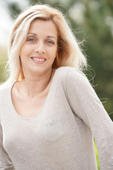 Portrait of attractive blond woman standing outside