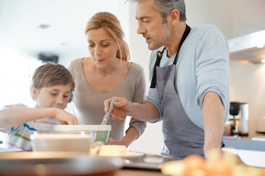 Family cooking together in modern home kitchen