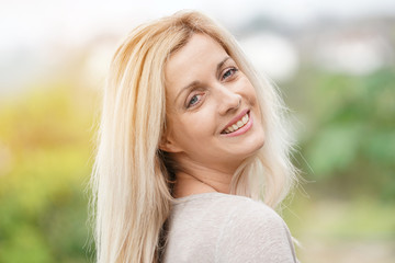 Portrait of attractive blond woman standing outside