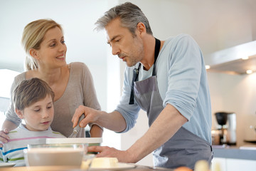 Family cooking together in modern home kitchen