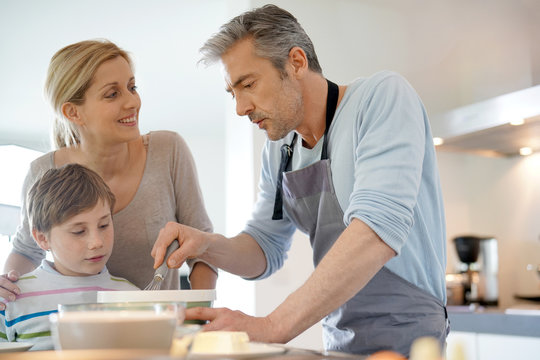 Family cooking together in modern home kitchen