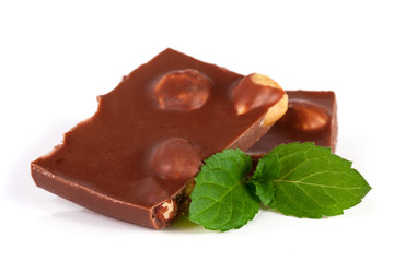 Chocolate with hazelnuts with mint leaves isolated on white background