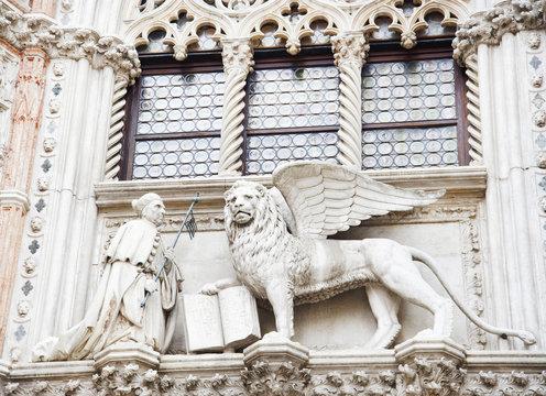 The Doges Palace - architectural detail. Winged lion, symbol of the city, with the Doge, on the facade of the building. Venice, Italy, Europe