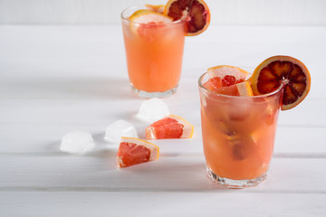 Grapefruit cocktail with ice and sliced fruit, selective focus