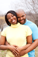 Loving happy African American couple hugging and smiling.