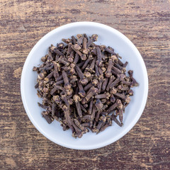 cloves in a bowl on wooden table
