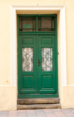 Fototapeta na wymiar The vintage green design brown wooden front door of an old house
