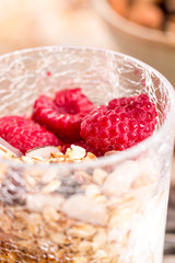 cup of yogurt with granola and raspberry