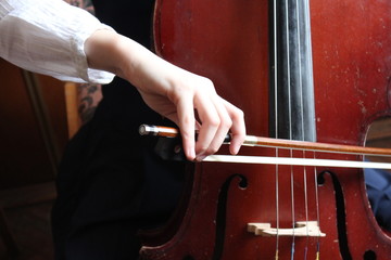 The girl is playing cello during the music lesson © Olha