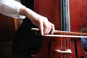 The girl is playing cello during the music lesson