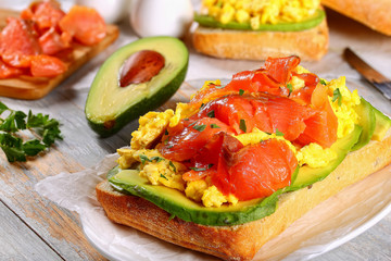 sandwich with salmon, avocado, scrambled eggs