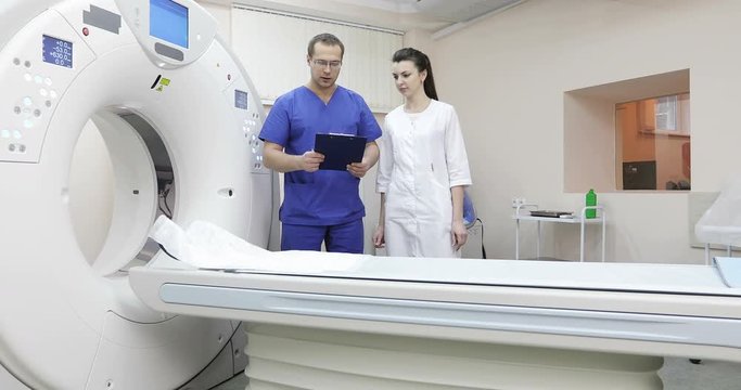 4K Doctor looking at computer screen while patient moving in mri machine.