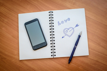 Drawn heart with an arrow in notepad