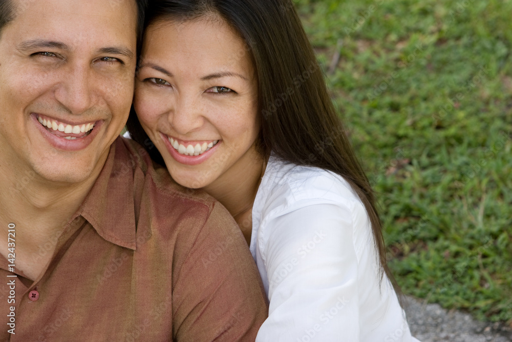 Wall mural Portrait of an Asian couple laughing and hugging.