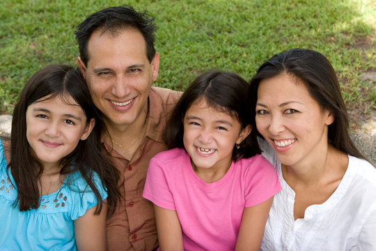 Loving Asain Parents And Their Daughters Smiling.