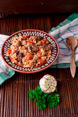 Pilaf on the brown plate on a wooden table, background. Rustic style