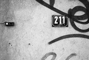 Old ruined wall with street number 211.