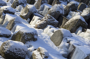 Snow-covered boulders on the granite cascade in icy system of ponds of Tsarskoye Selo(St.Petersburg).