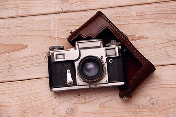 Old retro camera on vintage wooden boards abstract background