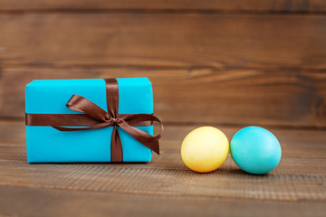 Light blue and yellow Easter eggs and the box on a wooden background. Place for inscription. Concept Happy Easter.