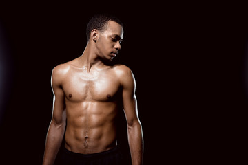 Fototapeta na wymiar Handsome african american muscular man posing on black