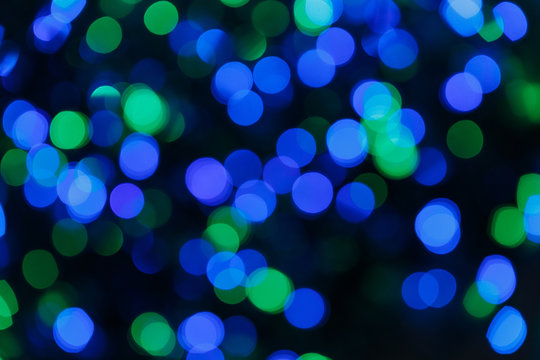 Blurred lights blue background. Glittering christmas effect. Abstract colorful pattern. Shimmering blur spots. Festive design.