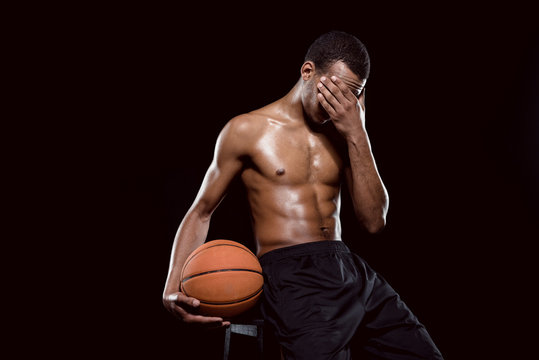 Tired African American Basketball Player With Ball On Black