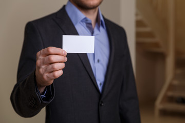 Businessman holding visit card. Man showing blank business card. Person in black suit. Mock up design.