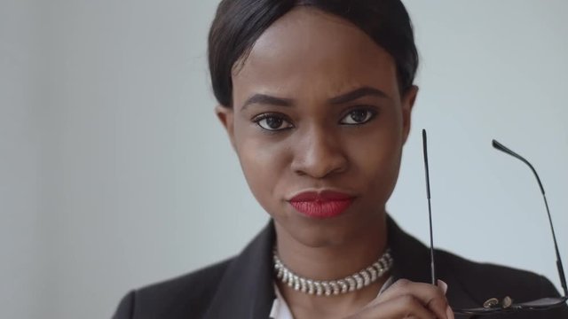 Shoked black woman takes off her glasses