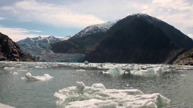 Moving Ice Floes on background of mountain and water Pacific Ocean in Alaska. Amazing landscapes. Beautiful rest and tourism in a cool climate. Unique picture of nature in America.